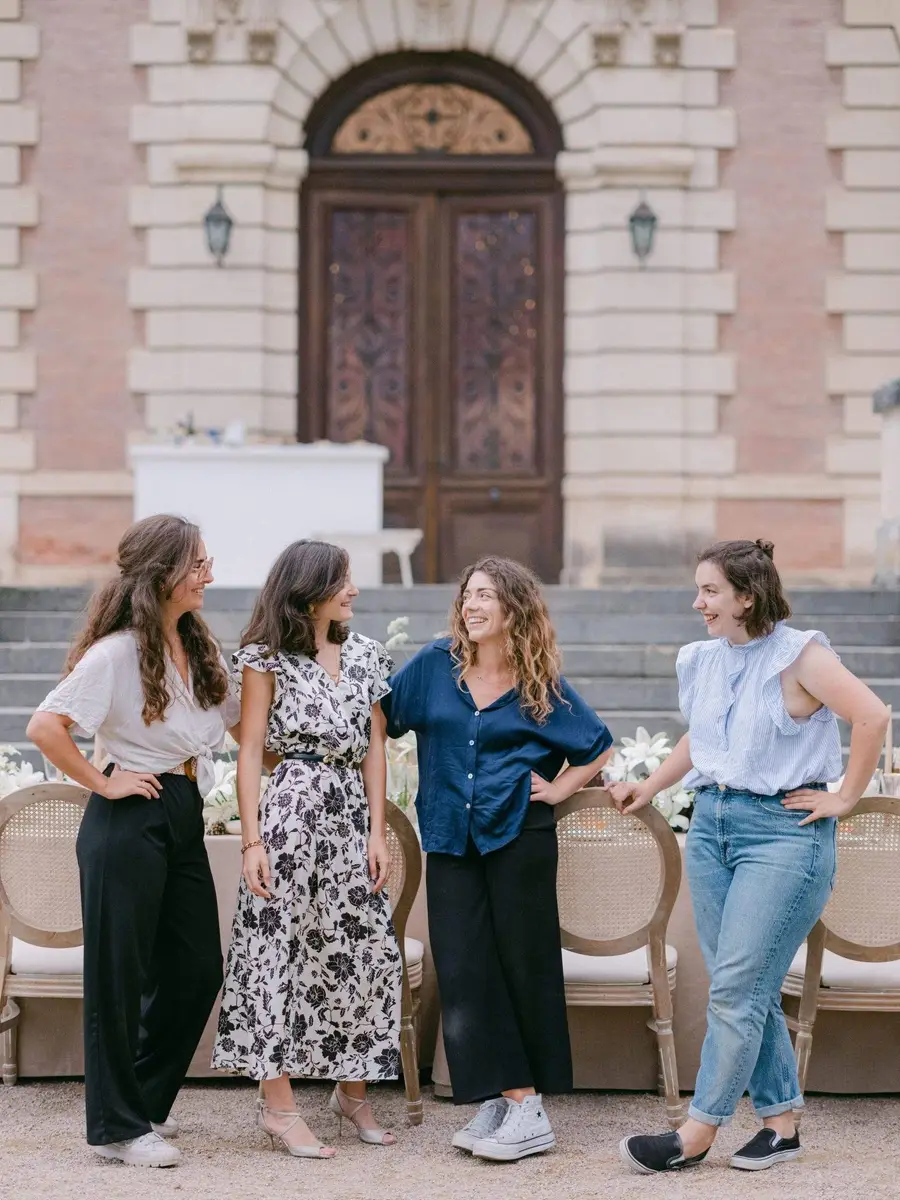 Julie Nagy and her team laughing in front of a château entrance